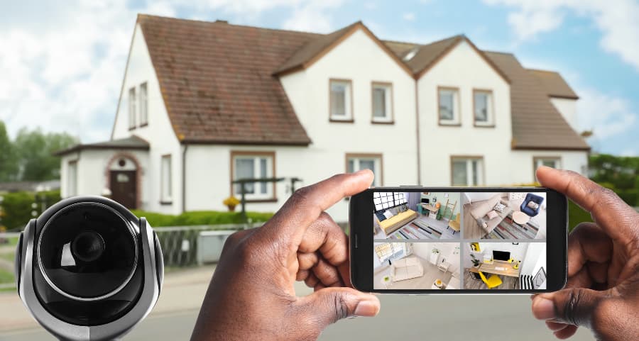 Man holding mobile device and viewing footage from surveillance cameras